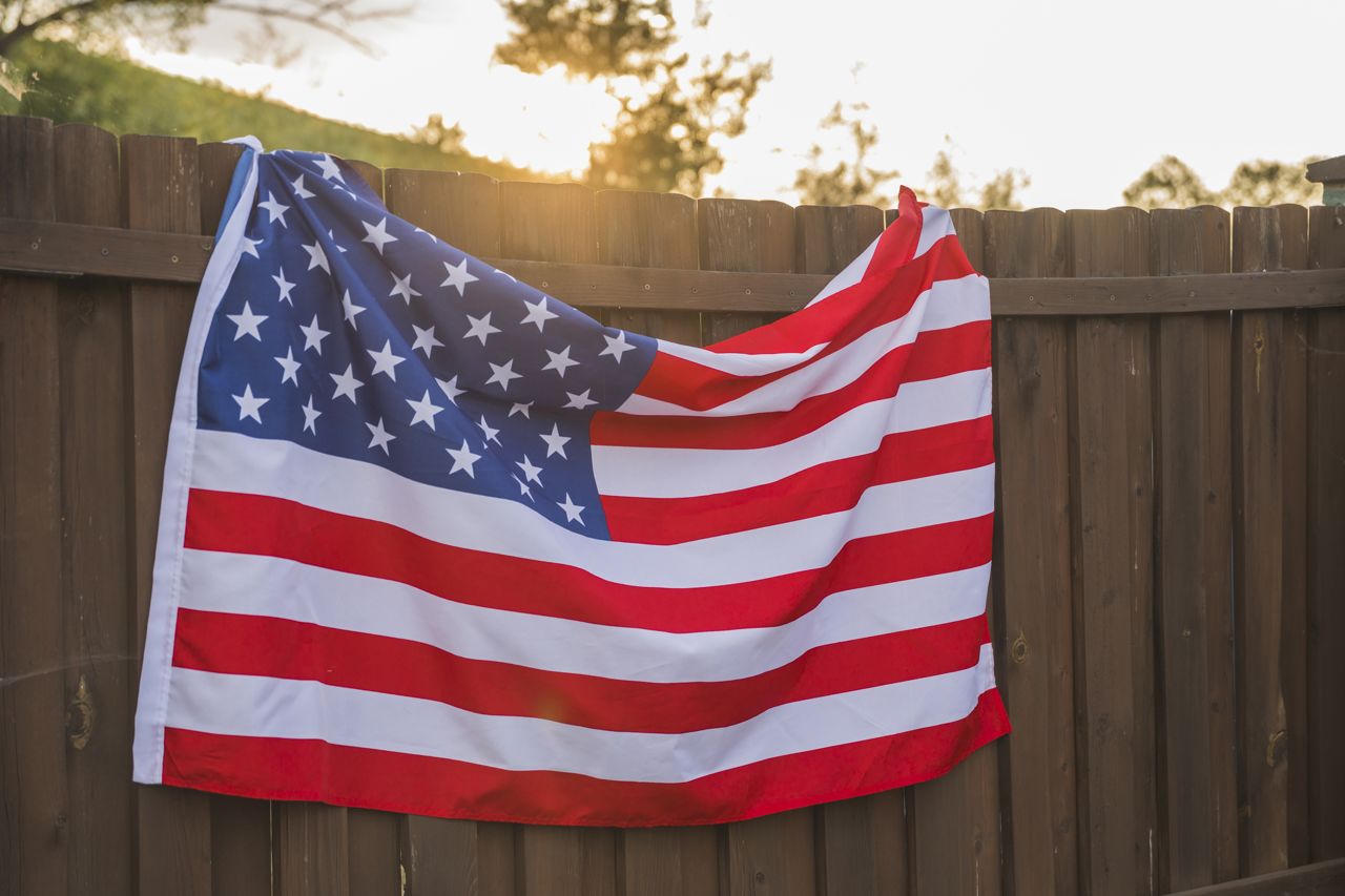 American Flag draped over fence